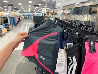 A pair of Under Armour shorts held out from clothing rack.