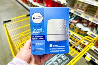 hand holding febreze plug oil diffuser next to yellow cart