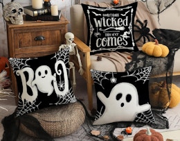 Halloween ghost pillows next to Halloween decorations