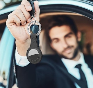 a guy holding keys with an airtag holder