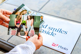 hands holding photographs in front of Walgreens photo envelope