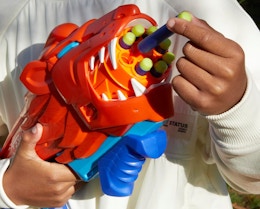 a person holding a lion-shaped dart blaster 