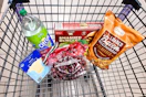 soda, burgers, chips, sliced cheese, and grapes in a cart