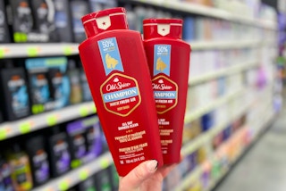hand holding two bottles of champion old spice body wash in a store
