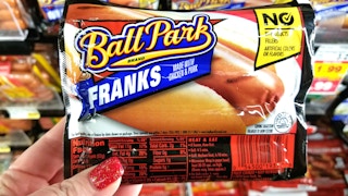 hand holding pack of Ball Park franks