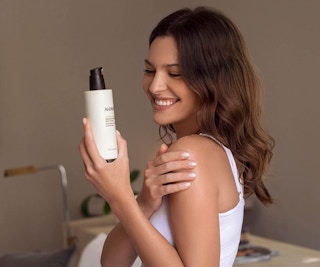 a woman holding a body of lotion