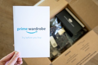 An amazon prime wardrobe info pamphlet with an open box filled with packaged clothing in the background