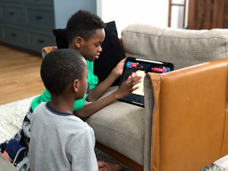 Two boys looking at a tablet.