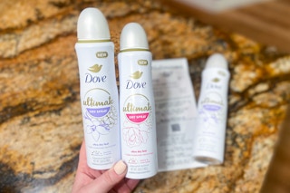 hand holding two dove dry spray deodorant
