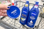 hand holding nivea body lotion next to two bottles of nivea lotion