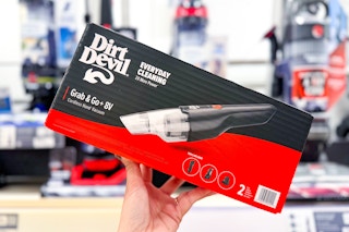 Holding a box of a Dirt Devil handheld vacuum infront of other vacuums in Target