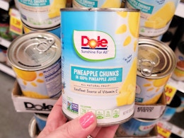 hand holding can of dole pineapple