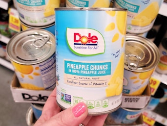 hand holding can of dole pineapple