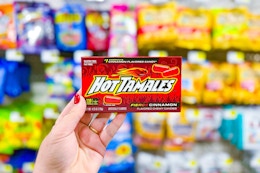 hand holding up a box of hot tamales candy