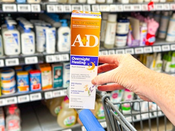 hand holding an a+d overnight healing ointment in front of a target shelf