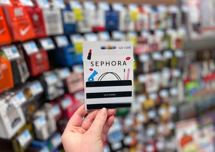 a person holding up a sephora gift card sold at Rite Aid