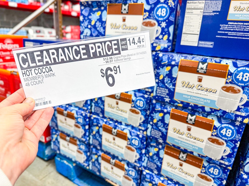 person holding a sign for $6.91 hot cocoa mix