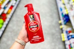 person holding a bottle of old spice shampoo in an aisle
