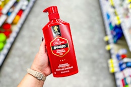 person holding a bottle of old spice shampoo in an aisle