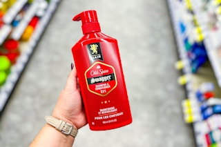 person holding a bottle of old spice shampoo in an aisle