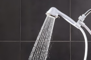 Lifestyle image of Waterpik Shower Head installed in shower with running water