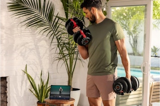 man using dumbbells in a room