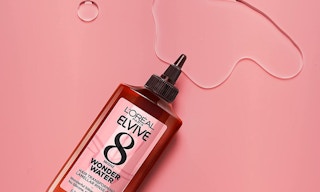 Brown and pink treatment bottle spilled on a pink background