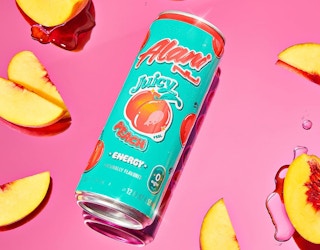 a teal and orange energy drink can next to slices of peaches