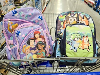 disney princess and bluey backpacks in a cart