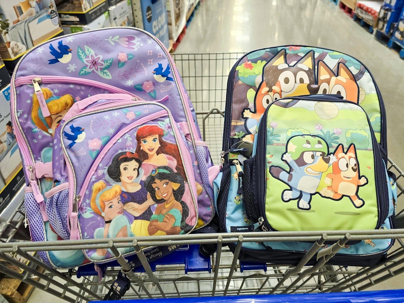 disney princess and bluey backpacks in a cart