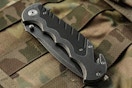 Smith & Wesson Benji 2.5in High Carbon Knife on a camo bag.