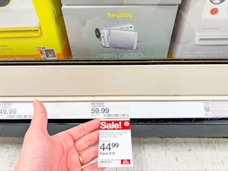 hand holding target sale sign in front of heyday camcorder on shelf