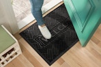 a person stepping on a welcome mat at a front door