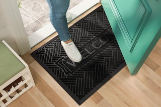 a person stepping on a welcome mat at a front door