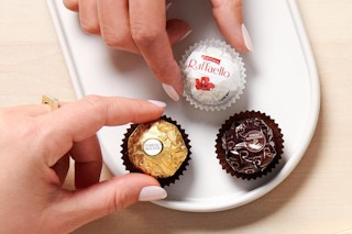 a person eating ferrero rocher chocolate