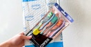 person holding reach essentials toothbrushes and caps along with amazon package