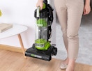 a person holding a green vacuum NEU10AE4