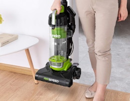 a person holding a green vacuum NEU10AE4