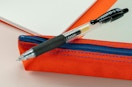 a black gel pen on a red pouch