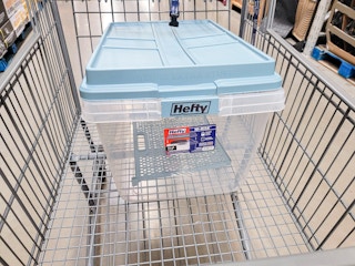 a clear 72 gallon storage tote with a blue lid in a cart