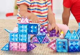 childing playing with blue, purple, and pink magnetic tiles