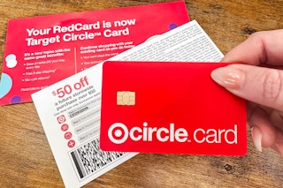 hand holding target circle card near mail on a table 