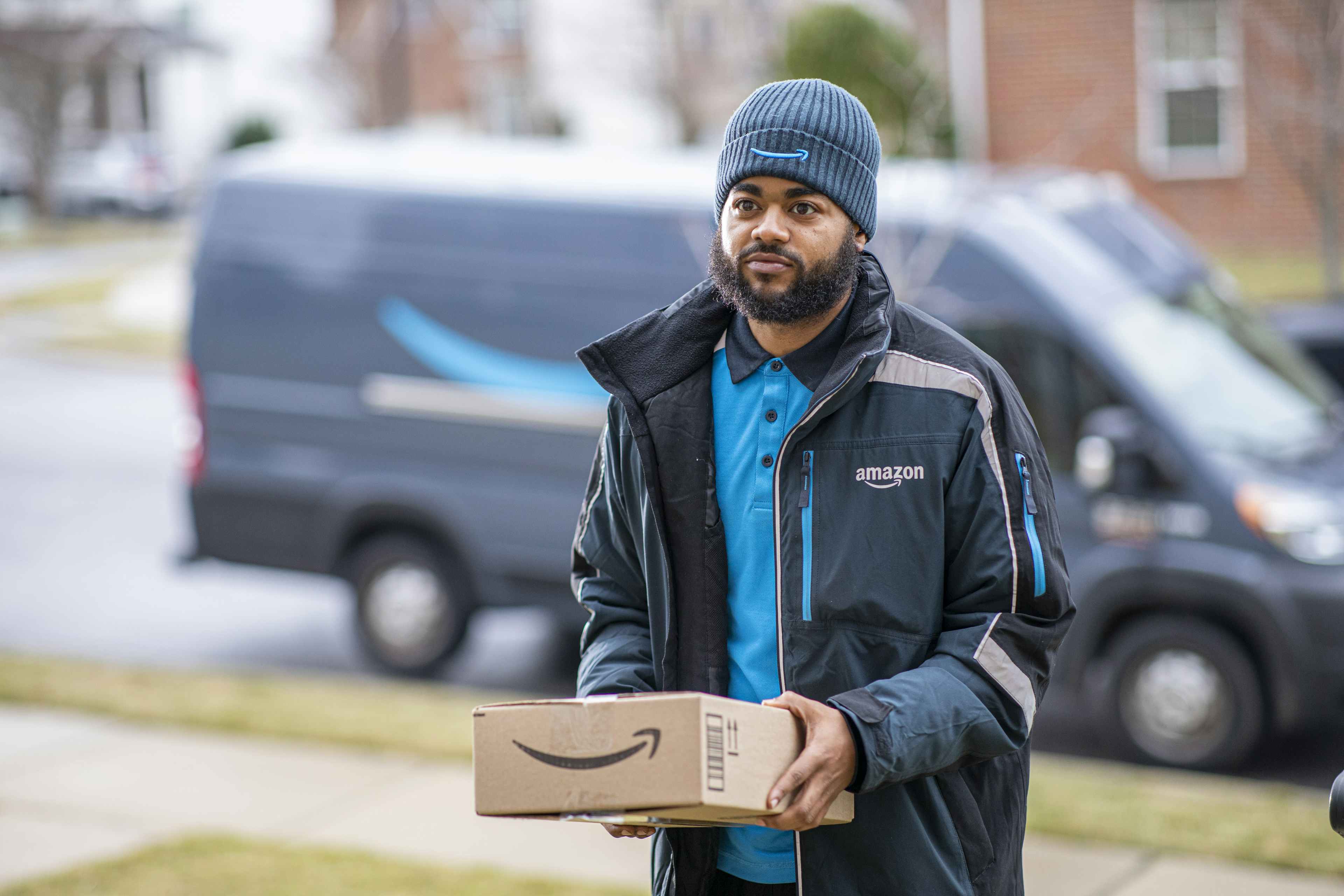 an amazon delivery driver holding a package