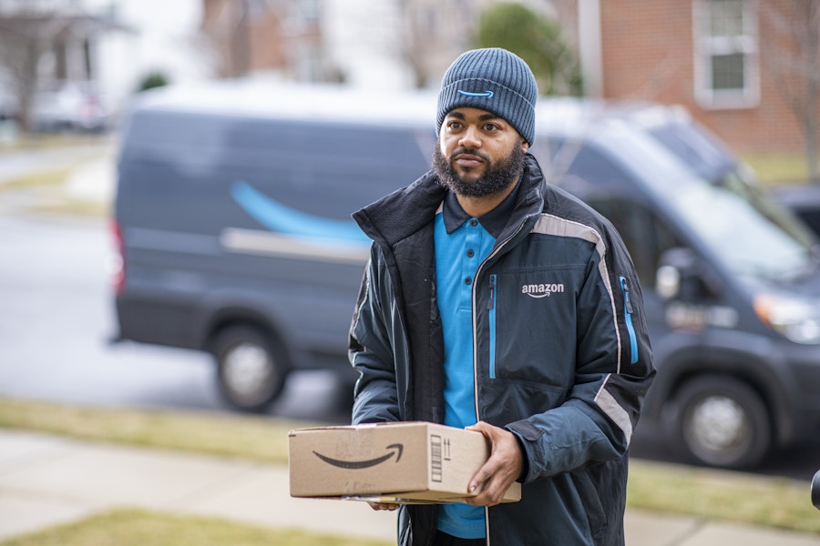 an amazon delivery driver holding a package