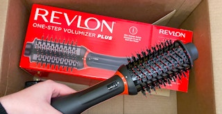 hand holding a revlon one step volumizer plus over a box
