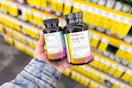 person holding 2 bottles of cvs health vitamins