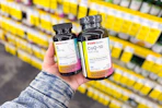 person holding 2 bottles of cvs health vitamins
