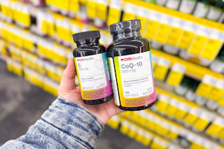 person holding 2 bottles of cvs health vitamins