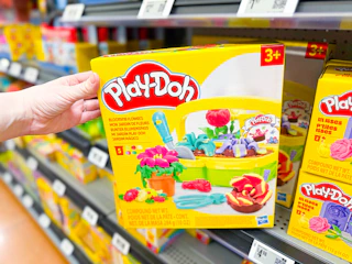 hand holding playdoh blooming flowers playset on walmart shelf