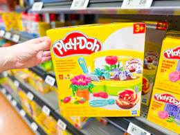 hand holding playdoh blooming flowers playset on walmart shelf